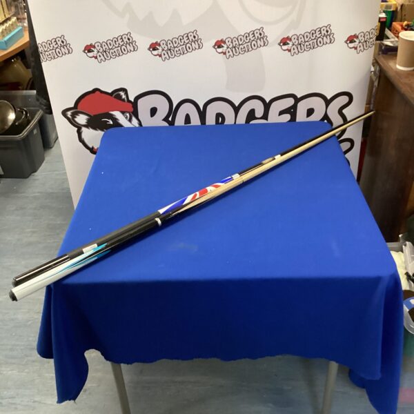 Pair of pool cues including a BCE model on a blue table.