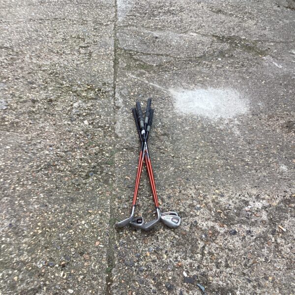 Set of used golf training clubs for practice.