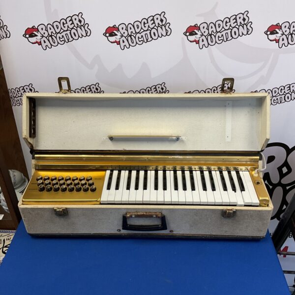 Vintage electric travel organ with keys and controls.