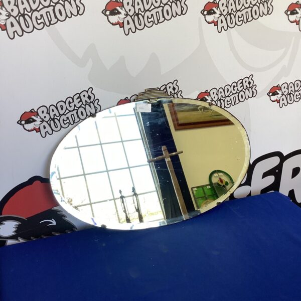 Vintage oval mirror with bevelled edge for elegant wall decor.