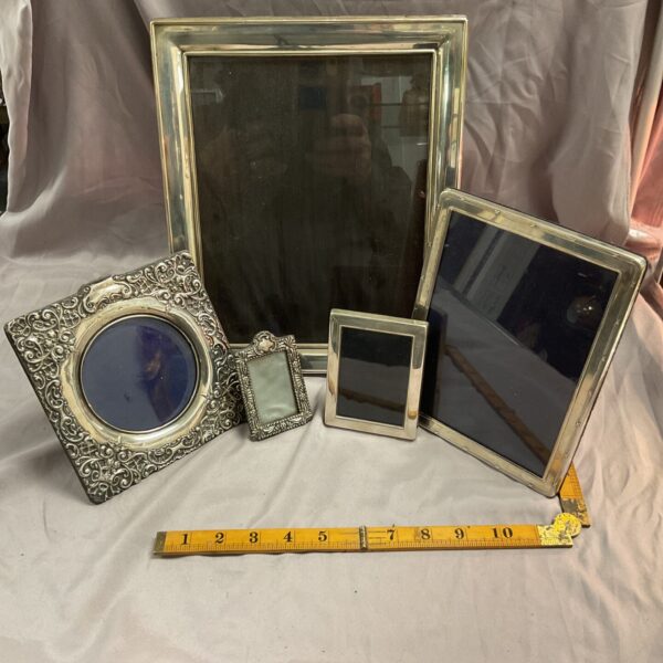 Lot of five antique hallmarked silver picture frames with ornate detailing.