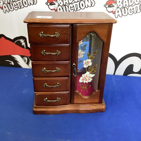 Vintage musical jewel box with floral details and a drawer.