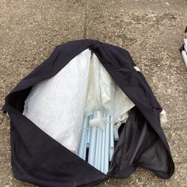 Silver gazebo folded in storage bag for outdoor use.