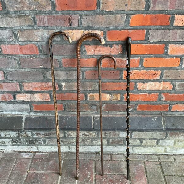 Four vintage walking canes including one with silver cuff