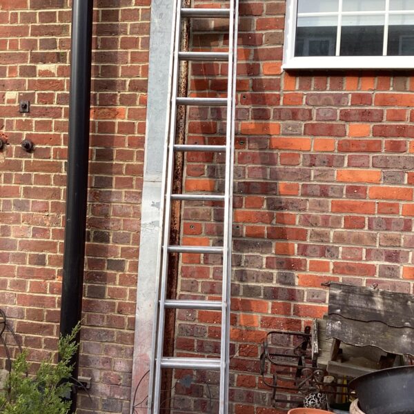 Two-piece aluminium ladder leaning against a wall.