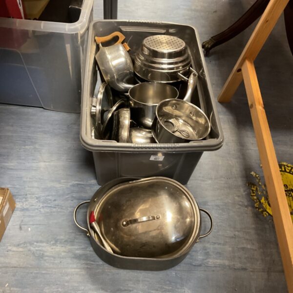 Stainless steel crockery lot in a plastic container.