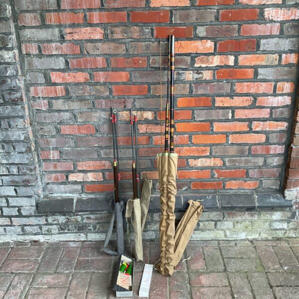 Vintage fishing rods displayed against a brick wall.
