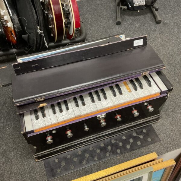 Vintage harmonium with keyboard and bellows, antique musical instrument.
