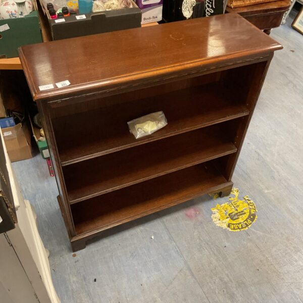 Vintage mahogany three tier bookcase for books and collectibles.