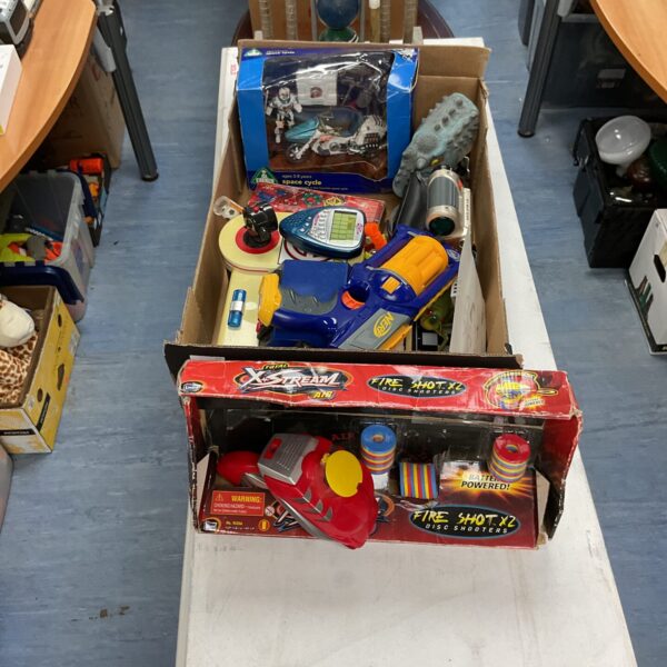 Crate of mixed toys including a Nerf gun and boxed items.
