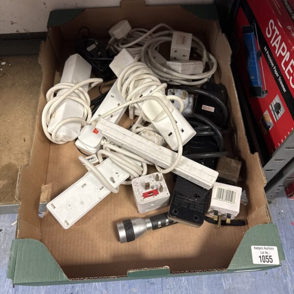 Assorted extension leads and power cables in a tray.