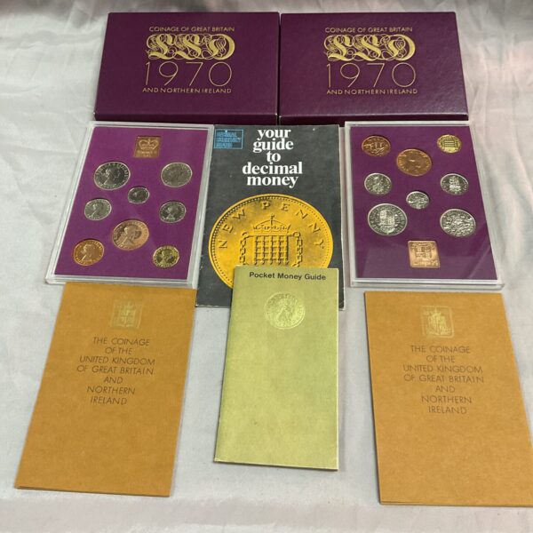 Front view of two 1970 Coinage of Great Britain sets and a decimal money guide.