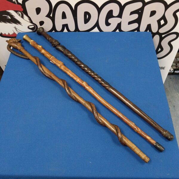 Lot of three vintage wooden walking sticks with unique designs.