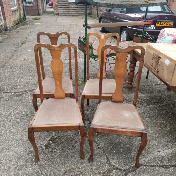 Set of four vintage wooden dining chairs in a room.