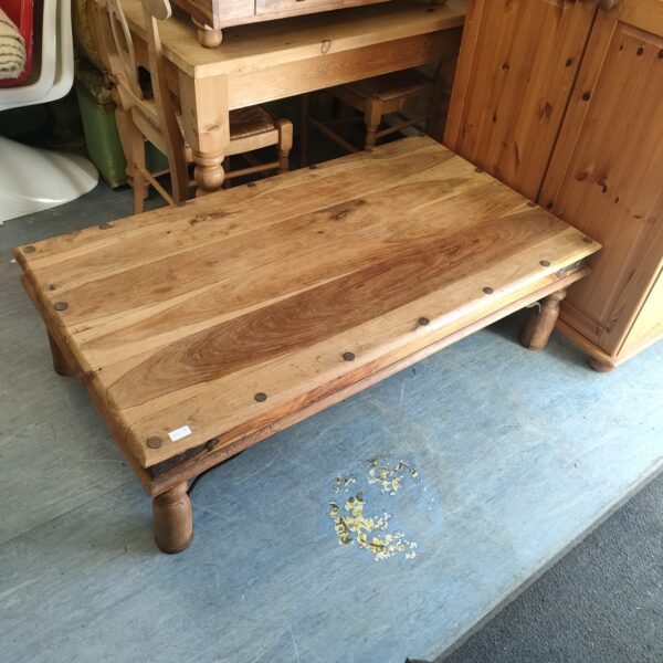 Rustic Indian coffee table made of solid oak with carved legs.