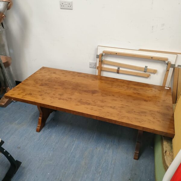 Detailed view of walnut coffee table with lion head carvings.