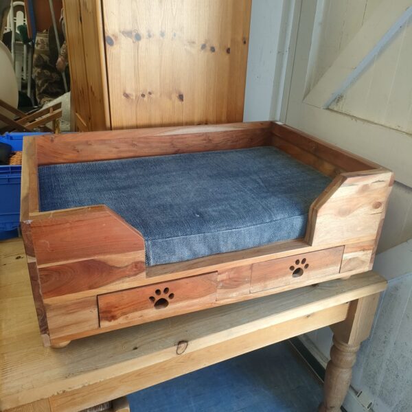 Handcrafted Indian oak dog bed with storage drawers for pet accessories.