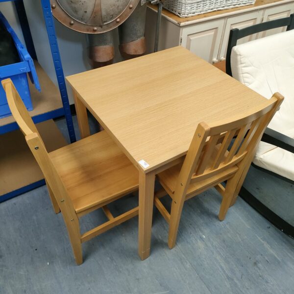 Vintage wooden dining set with table and two chairs.