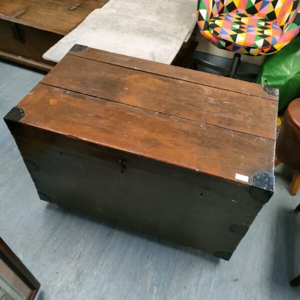 Vintage wheeled travel trunk with metal corners and aged wood.