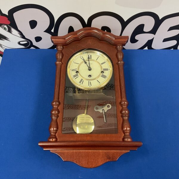 Vintage Hermle chiming wall clock with pendulum and Roman numerals.