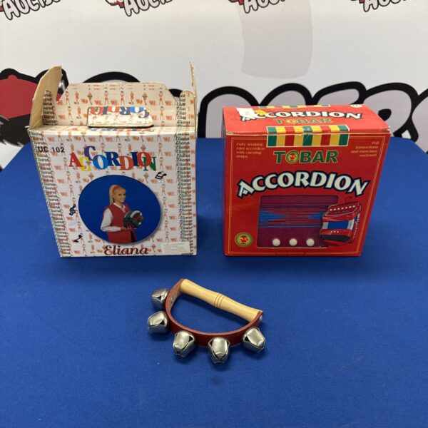 Vintage children’s accordions with jingle bells, colourful plastic bodies.