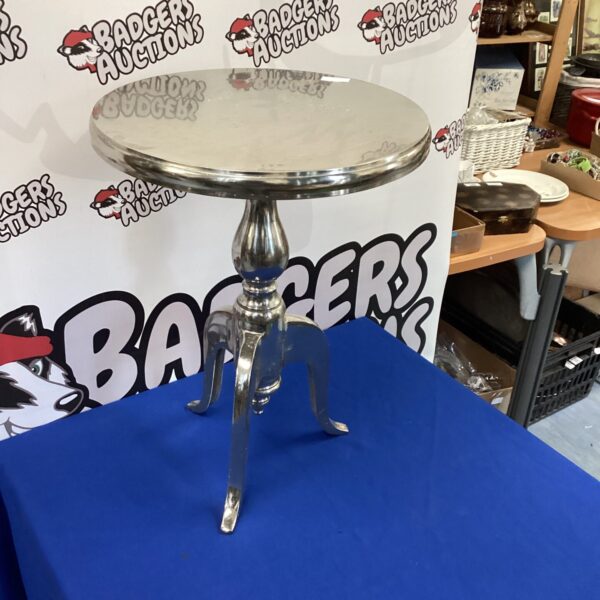Sleek stainless steel wine table with three legs.