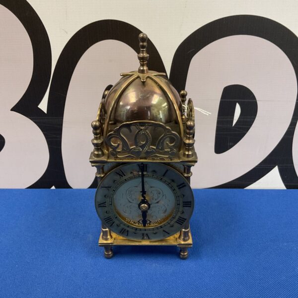 Antique brass lantern clock with Roman numerals, a vintage timepiece.