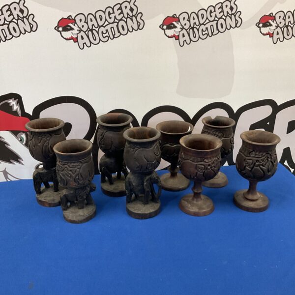 Set of four African carved wood goblets with animal designs.