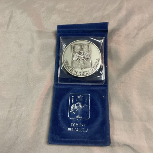 Front view of the Aquila commemorative medal, detailed relief work.