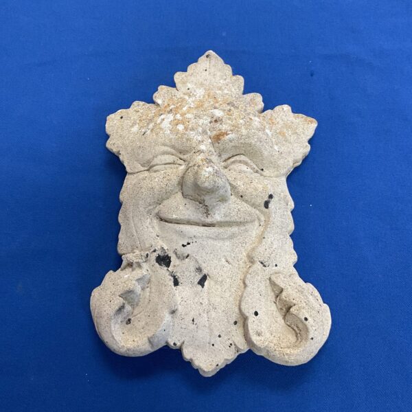 Detailed concrete Green Man plaque for garden decoration.