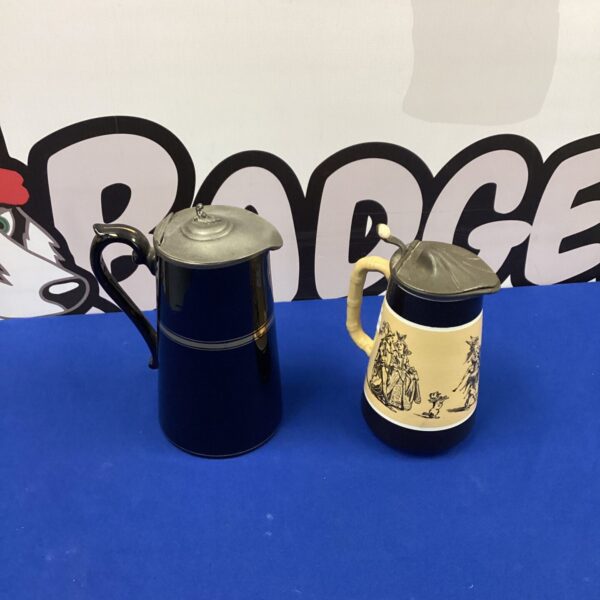 Pair of vintage ceramic milk jugs with transferware designs.