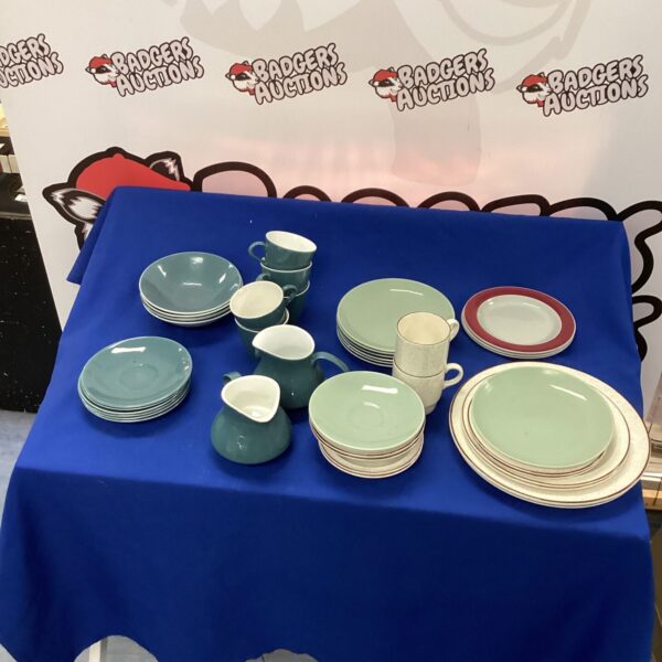 Vintage Poole Pottery collection of plates and bowls on display.
