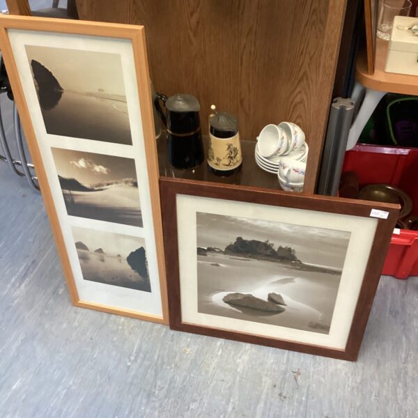 Two framed beach prints with calming coastal scenes.
