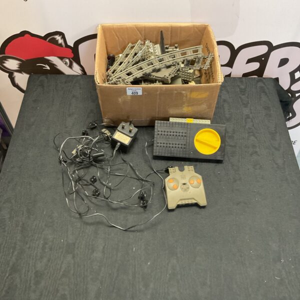 Vintage Lego train tracks and remote control unit in a box.