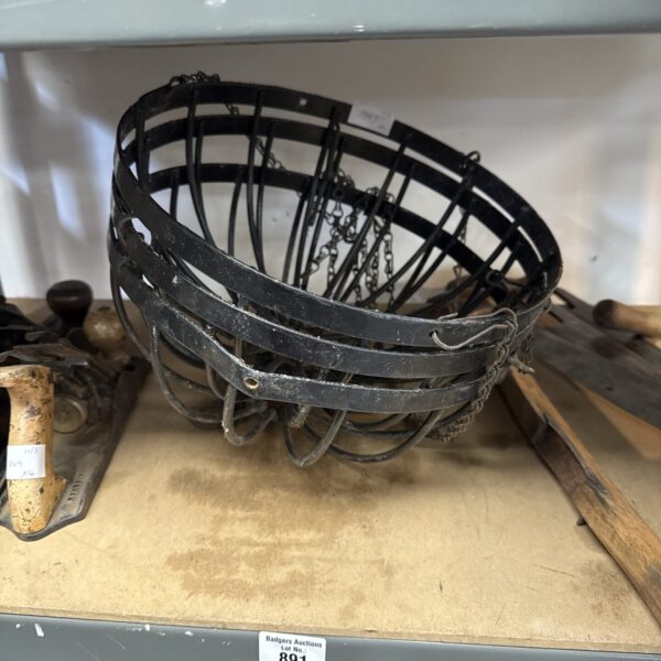 Vintage wrought iron hanging basket with chain, rustic garden decor.
