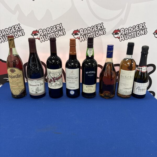 Assorted alcohol lot featuring brandy, wine, and prosecco bottles.
