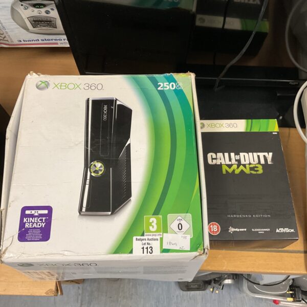Black Xbox 360 Slim console with game and controllers.