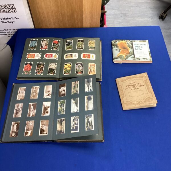 Four vintage cigarette card albums with cards inside.