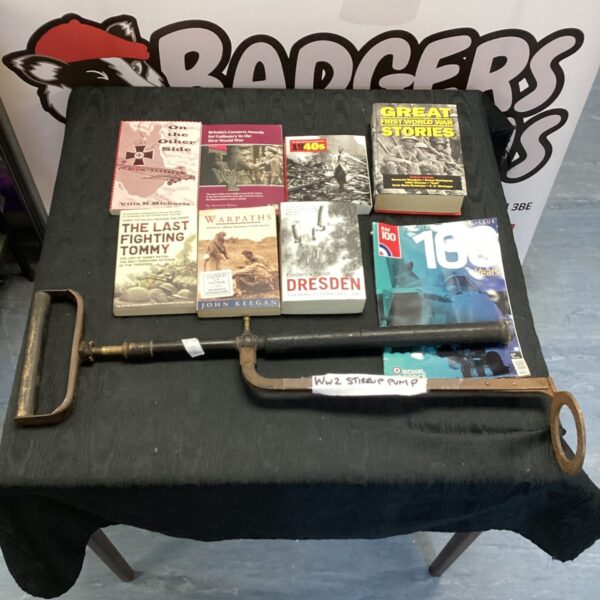 Vintage WW2 stirrup pump with military books for collectors.