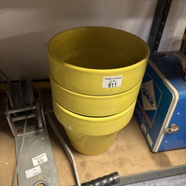 Three vintage yellow ceramic plant pots for garden decor.