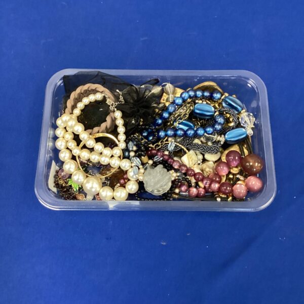 Assorted costume jewellery tray with necklaces and brooches.