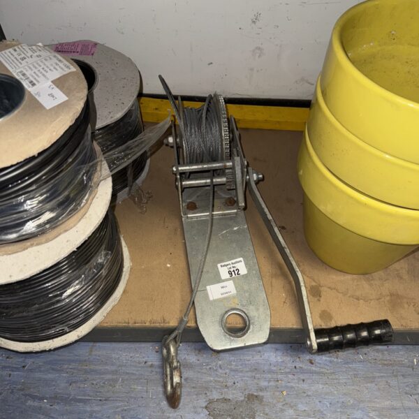 Side view of a vintage steel cable winch with cable spooled.