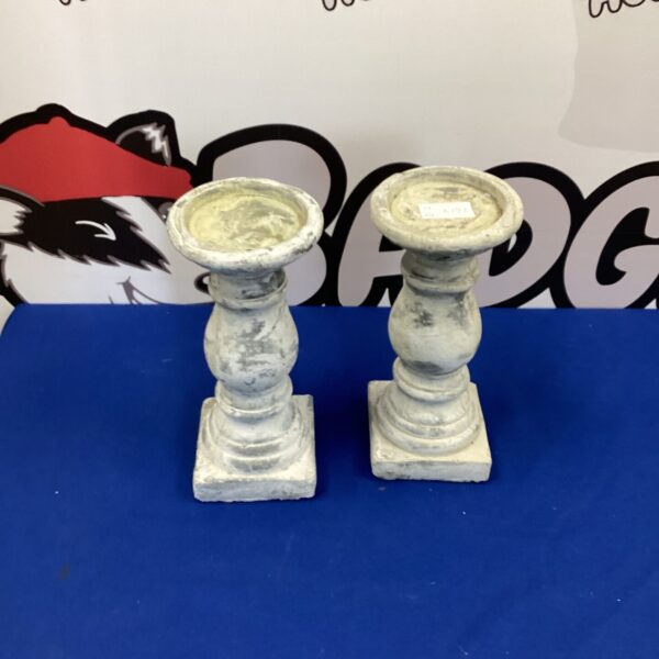 Pair of weathered stone candle holders for garden or patio use.