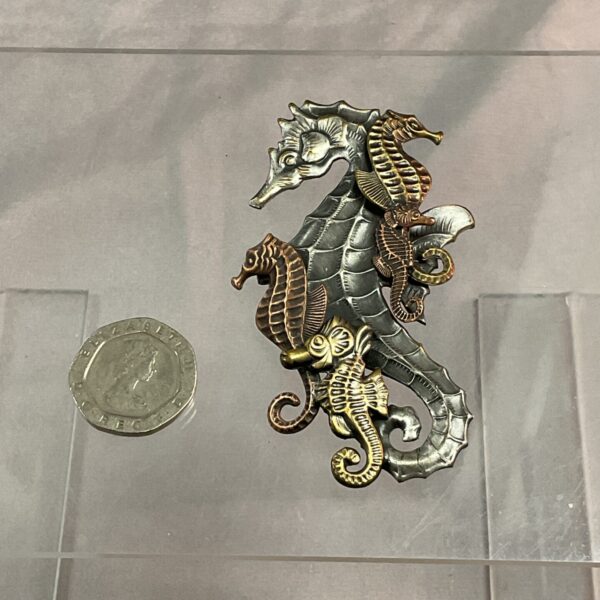 Vintage K&T seahorse brooch from the 1970s, detailed silver and gold tones.