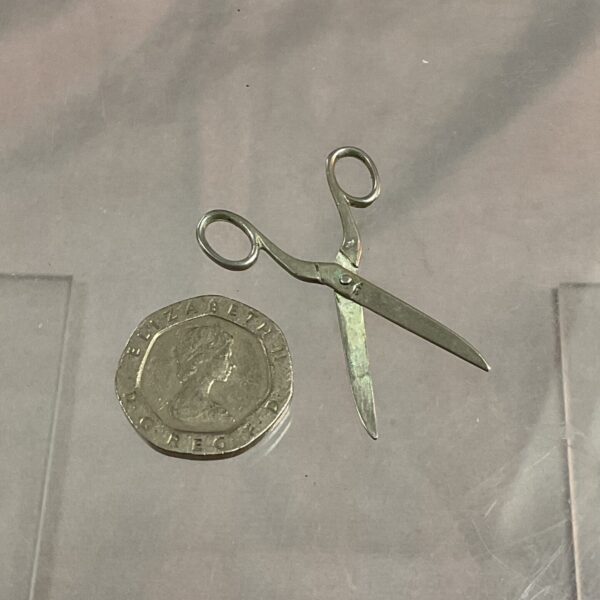 Close-up of antique miniature silver scissors, a collectible item.