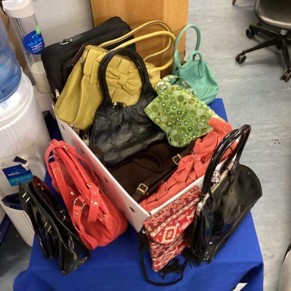 Mixed lot of colourful ladies handbags and purses.