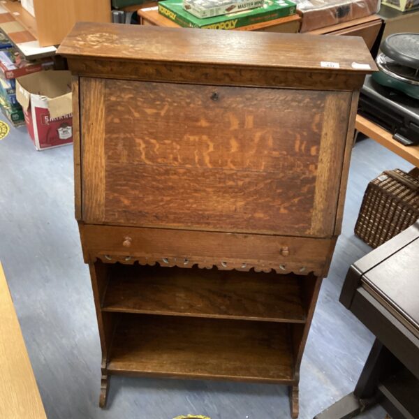 Front view of antique oak writing desk with roll top.