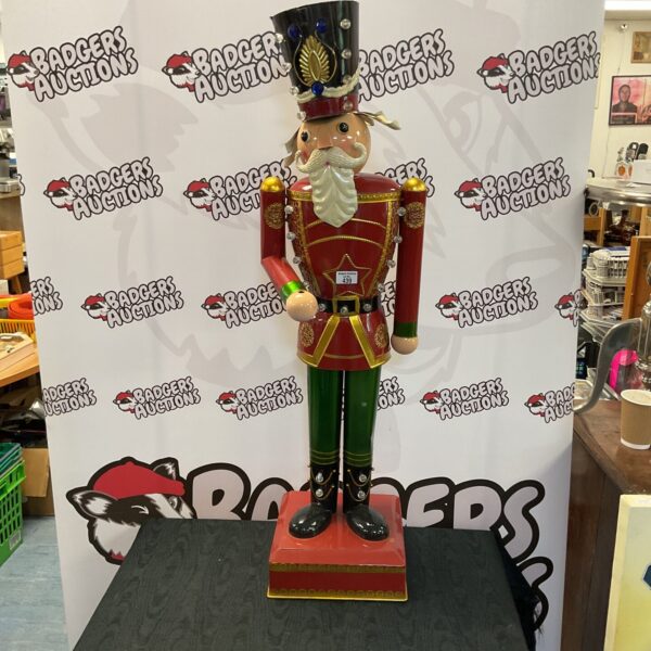 Detailed vintage tin nutcracker soldier on wooden base.