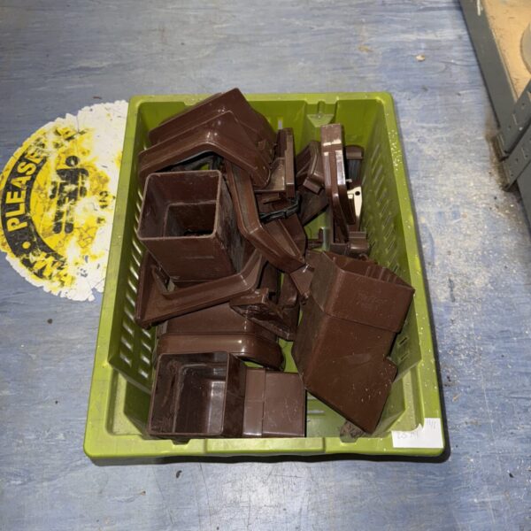 Collection of brown plastic drainpipe fittings for drainage systems.