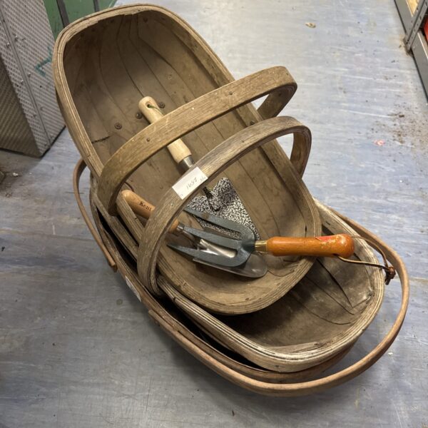 Vintage wooden garden trugs with hand tools for gardening.